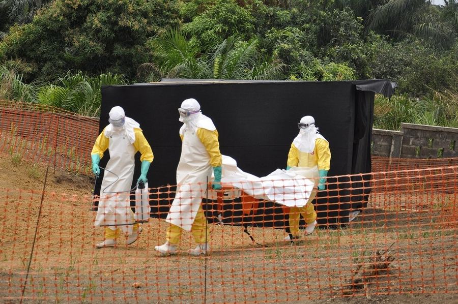 Тело пациента, умершего от лихорадки Эбола, переносят семье для захоронения. Тело промыто хлорированной водой и закрыто в непроницаемую оболочку.  © Амандин Колин / MSF