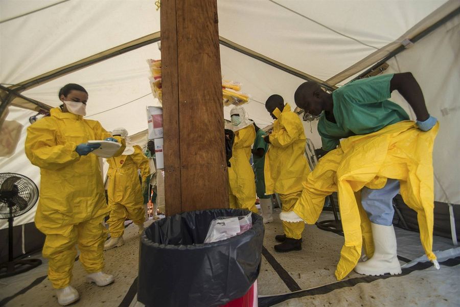 Сотрудники международной организации по оказанию медицинской помощи "Врачи без границ"  готовятся войти в изолятор.  (Кайлахун, 20 июля 2014). 